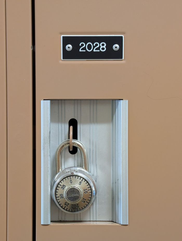 Close-up of a brown locker with a combination padlock and number 2028 visible. Secure and organized.