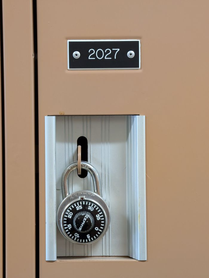 why-choose-us Close-up of a secure locker with a combination lock labeled 2027 indoors.